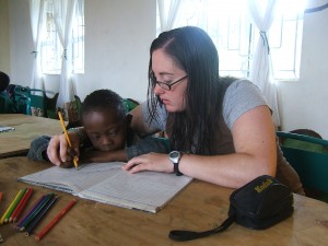 Crystal working hand over hand with special needs student in Tanzania